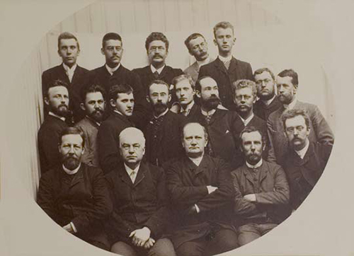Stortingsstenografene på 1890-tallet, med sjef Cappelen nederst som nummer to fra venstre. Oskar Kristiansen, som etter Cappelens død i 1900 tok over som den første rene referentsjefen, er nummer to fra høyre på samme rekke. Fortsatt hadde ikke kvinnene gjort sin inntreden. Olaf Albert Paulsen, som foreviget 7. juni-møtet, er for øvrig nummer tre fra høyre på midterste rad. Foto: Stortinget.
