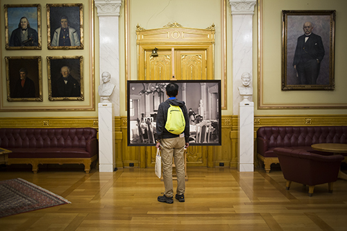 Nesten 1000 besøkende var innom Stortinget under kulturnatten i 2016. En gjest har stoppet i Eidsvollsgalleriet for å se bildekavalkaden med historiske bilder. Foto: Stortinget.