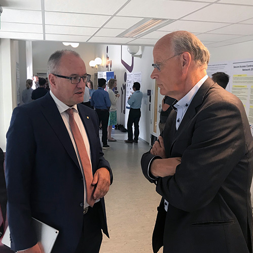 Michael Tetzschner i samtale med NTNUs rektor Gunnar Bovim. Foto: Stortinget.