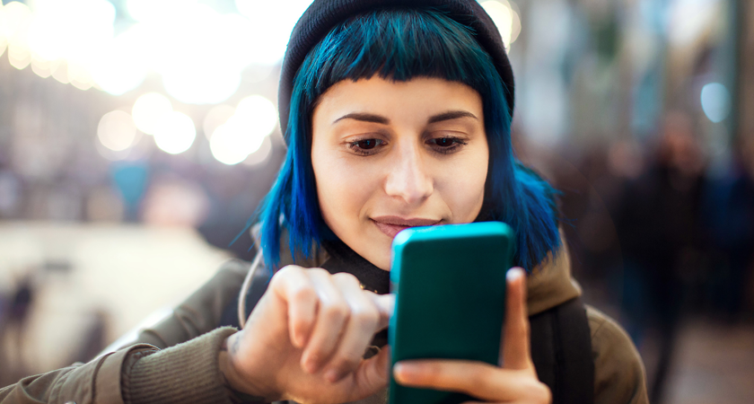 En jente skriver på mobiltelefonen sin.