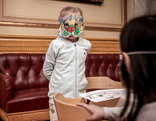 Girl with painted paper lion mask