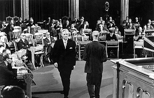 På bildet er John Lyng (Høyre), som overtok som statsminister, på vei mot Stortingets talerstol; Gerhardsen er på vei vekk.