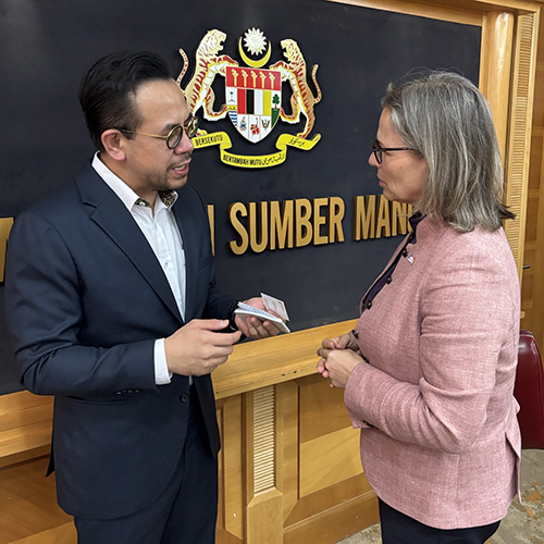 Trine Lise Sundnes (Ap) avbildet i samtale med Malaysias minister for arbeidsliv, Steven Sim Chee Keong.