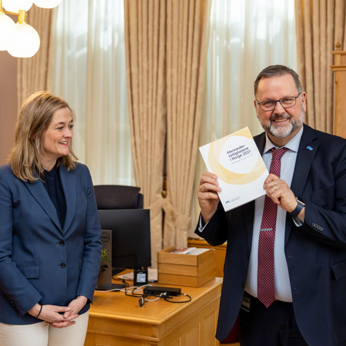 NIMs direktør Adele Matheson Mestad har levert NIMs årsmelding for 2021 til første visepresident Svein Harberg. Foto: Stortinget.