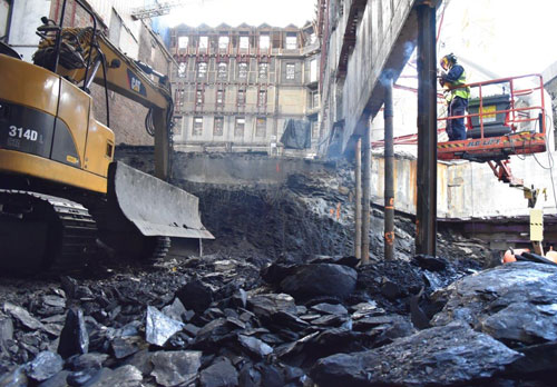 Det er risikabelt når manuelt arbeid pågår parallelt med at større maskiner arbeider på en trang byggeplass. Foto: Stortinget