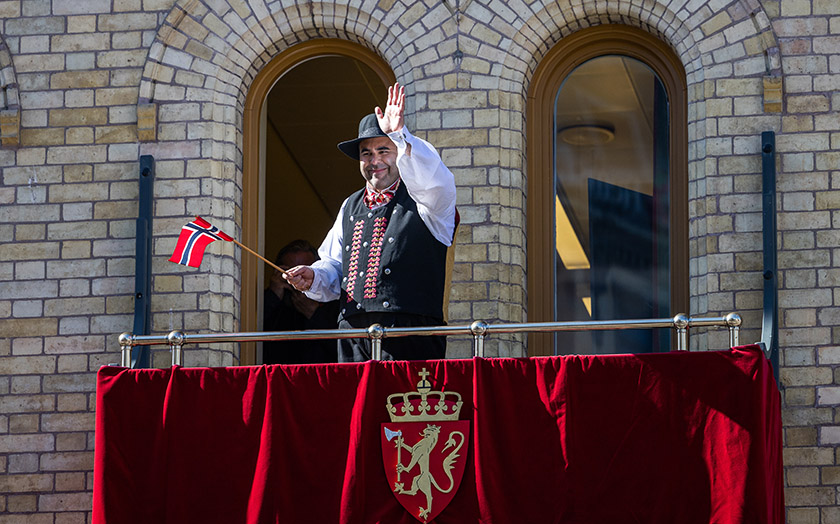 President of the Storting Masud Gharahkhani waving to the children’s parade from the balcony of the Storting. Photo: Storting.