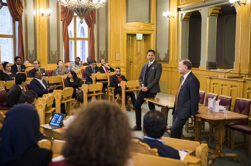 Local elected officials taking part in International Migrants Day with President of the Storting Olemic Thommessen (right) and Fifth Vice President Abid Raja. Photo: Storting.