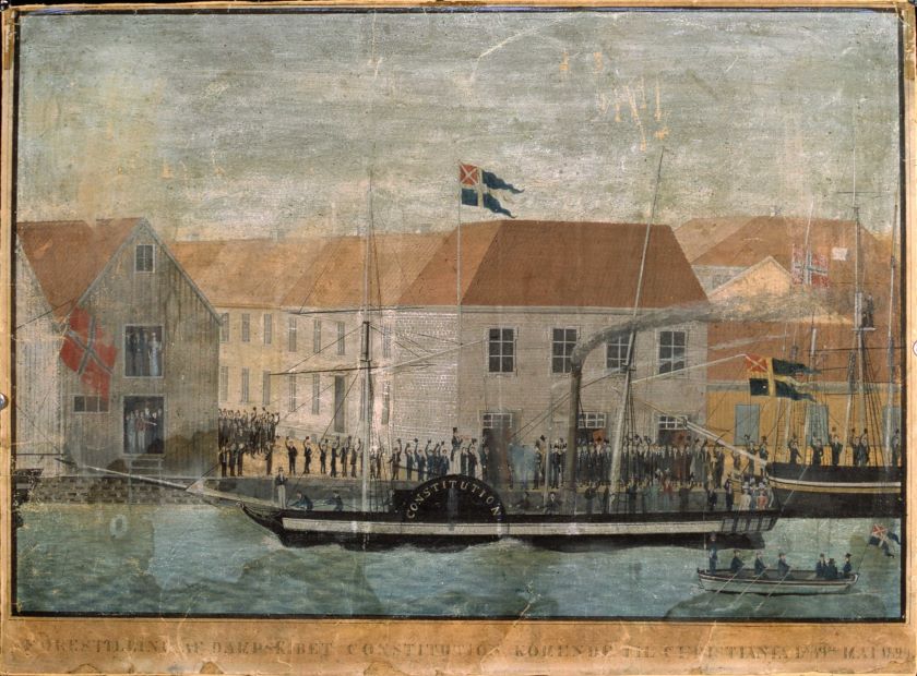 På bildet ser vi det norske handelsflagget og statsflagget med unionsmerket vaie side ved side på Tollbubryggen 17. mai 1829, da Norges første dampbåt, postskipet «Constitutionen» ankom Christiania. Gouache av Mathias Ferslev Dalager