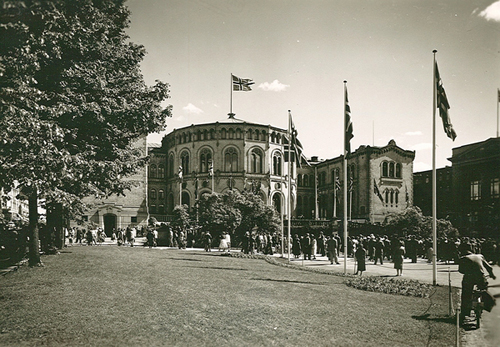 Stortinget og Eidsvolls plass den 7. juni 1955. Det gamle statsflagget med splitt vaiet over stortingsbygningen.