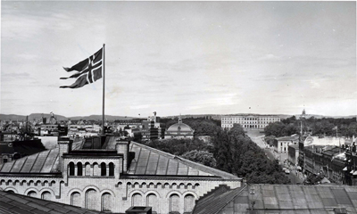 Det gamle statsflagget med splitt vaiet over stortingsbygningen den 7. juni 1955. Foto: stortingsarkivet.