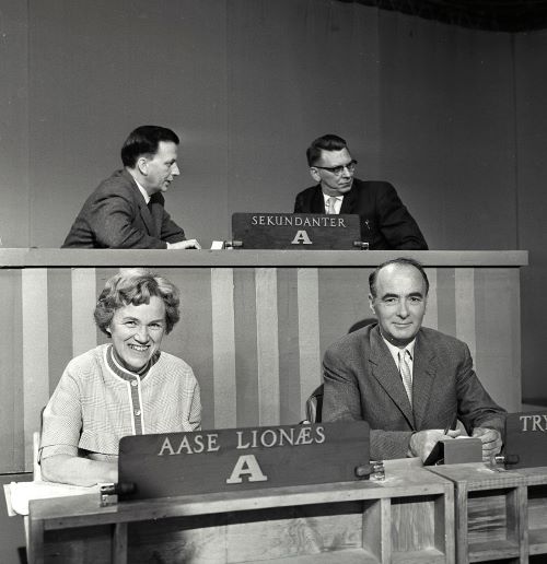 Fra utspørring i fjernsynet foran stortingsvalget 1961. Bak sitter sekretær i Arbeiderpartiets stortingsgruppe Inge Scheflo (til v.) og redaktør i Arbeidernes Pressekontor Olav Brunvand. Foran Arbeiderpartiets stortingsrepresentant Aase Lionæs og partiets nestformann Trygve Bratteli, september 1961.